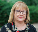 Headshot of Ann Bartuska against green background