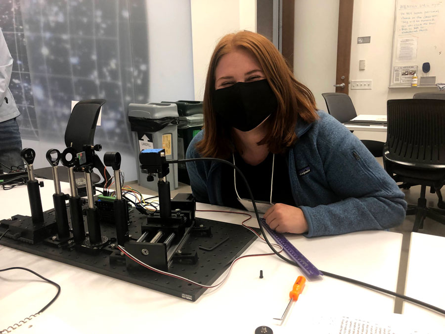 Katelyn posing with an optical spectrograph she built.