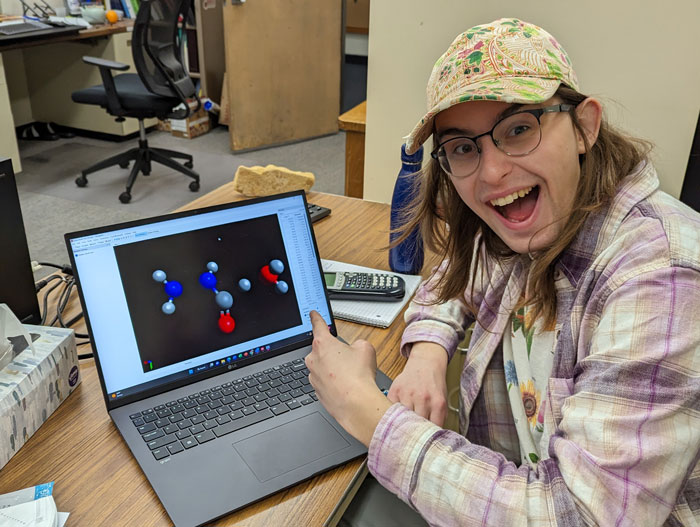 Evie Harel in front of a computer modeling molecules.
