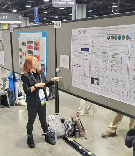 Yuri in front of a poster at AGU