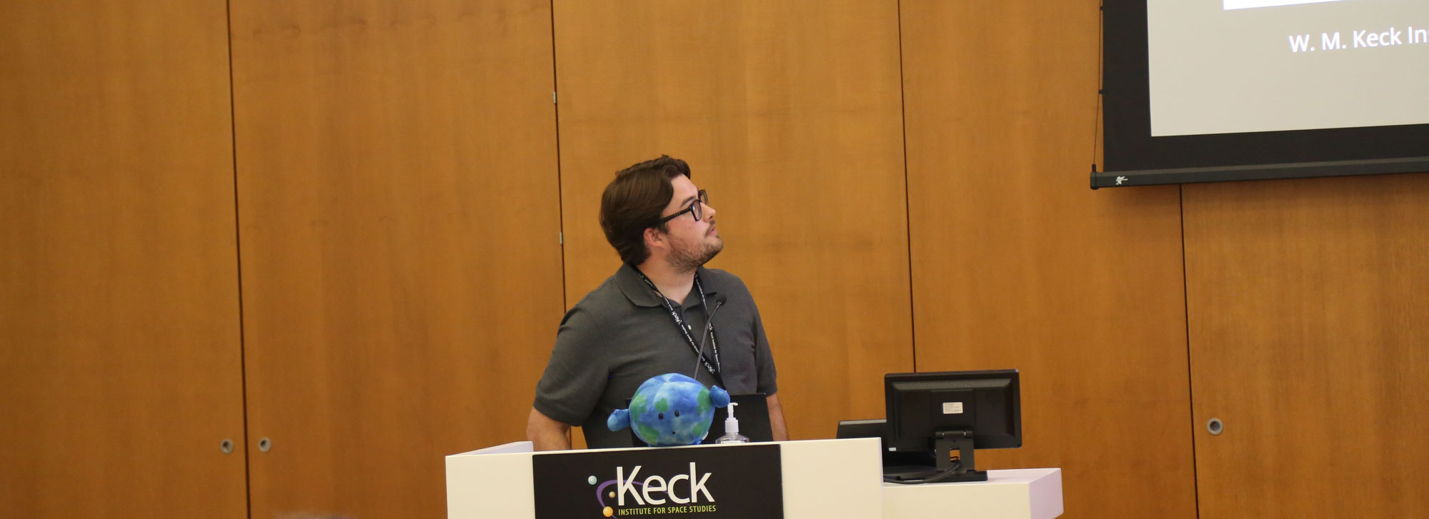 man with glasses presents from a podium