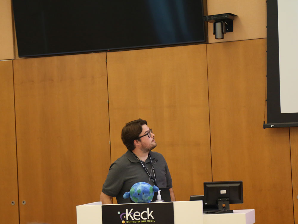 man with glasses presents from a podium