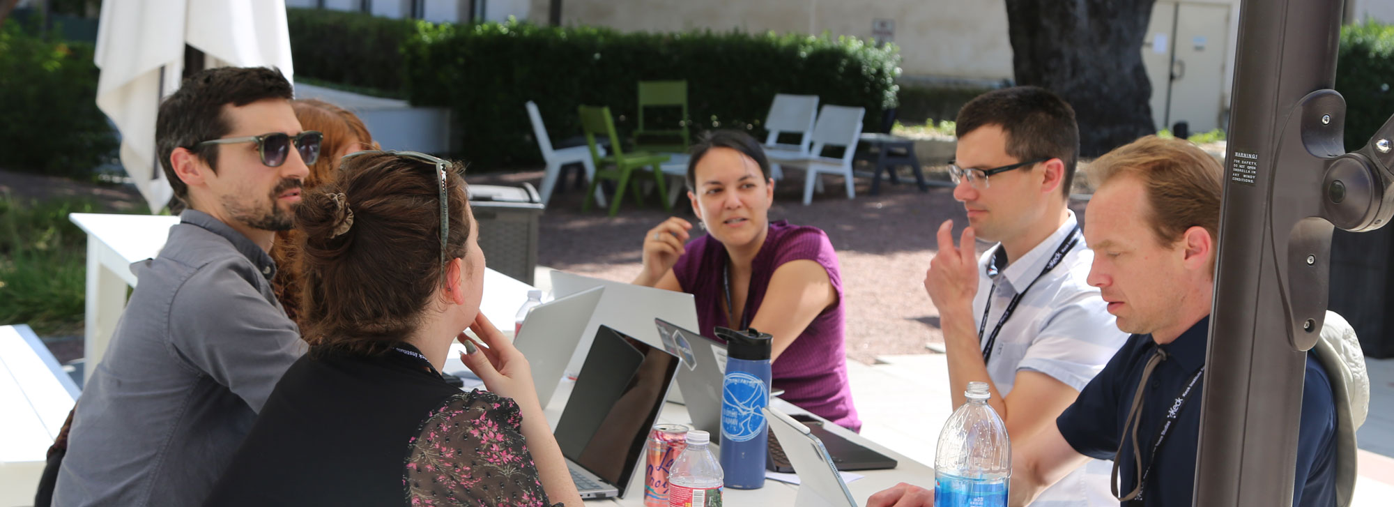 group discussing outdoors around a table