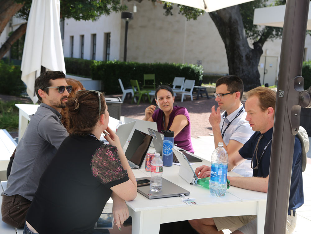 group discussing outdoors around a table